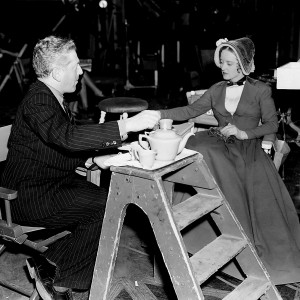 O diretor Anatole Litvak dá instruções para Bette na filmagem de Tudo Isto E O Céu Também